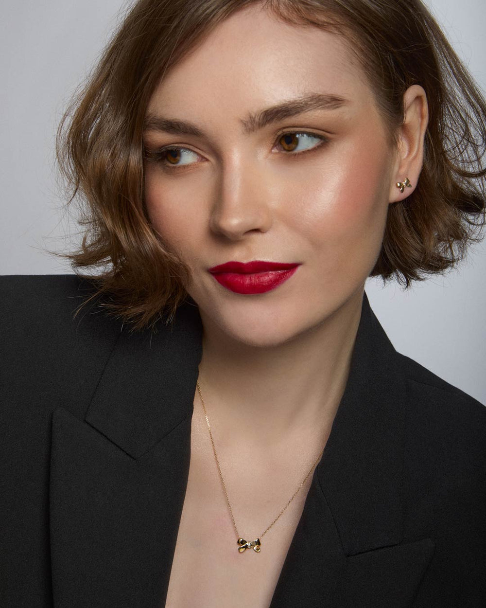 model wearing 9ct gold bow stud earrings and necklace set