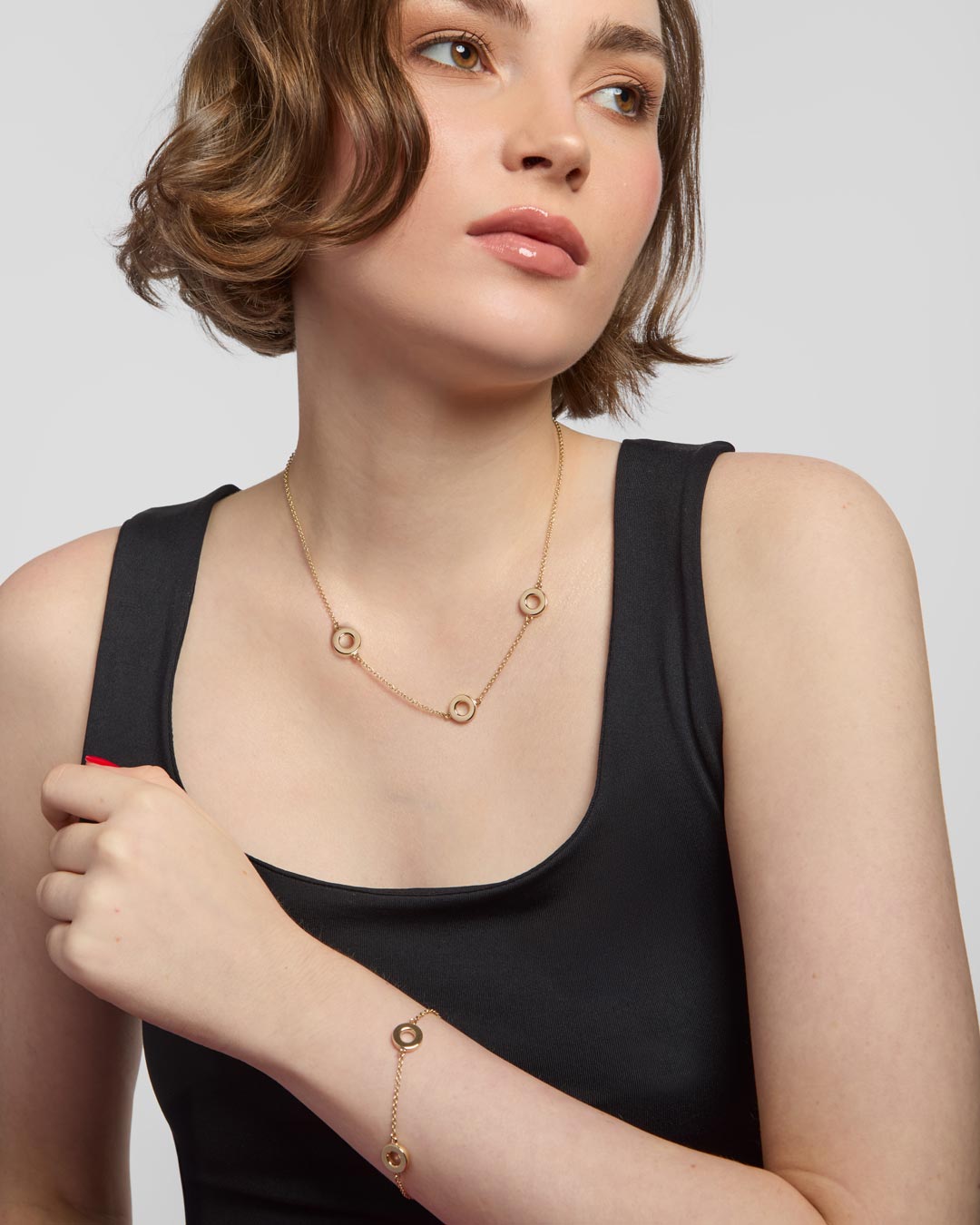 model wearing 9ct gold circle bracelet and necklace set