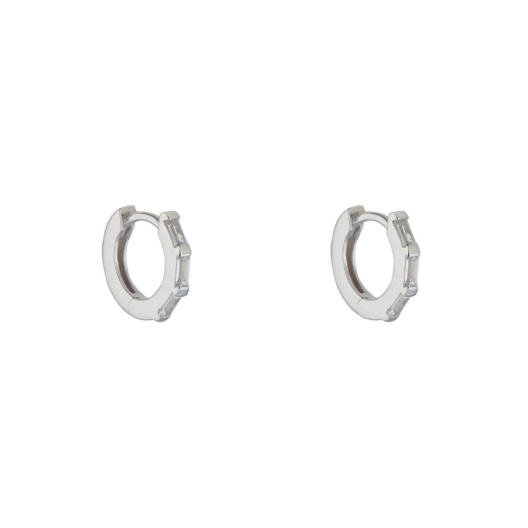 silver cubic baguette huggie earrings on white background