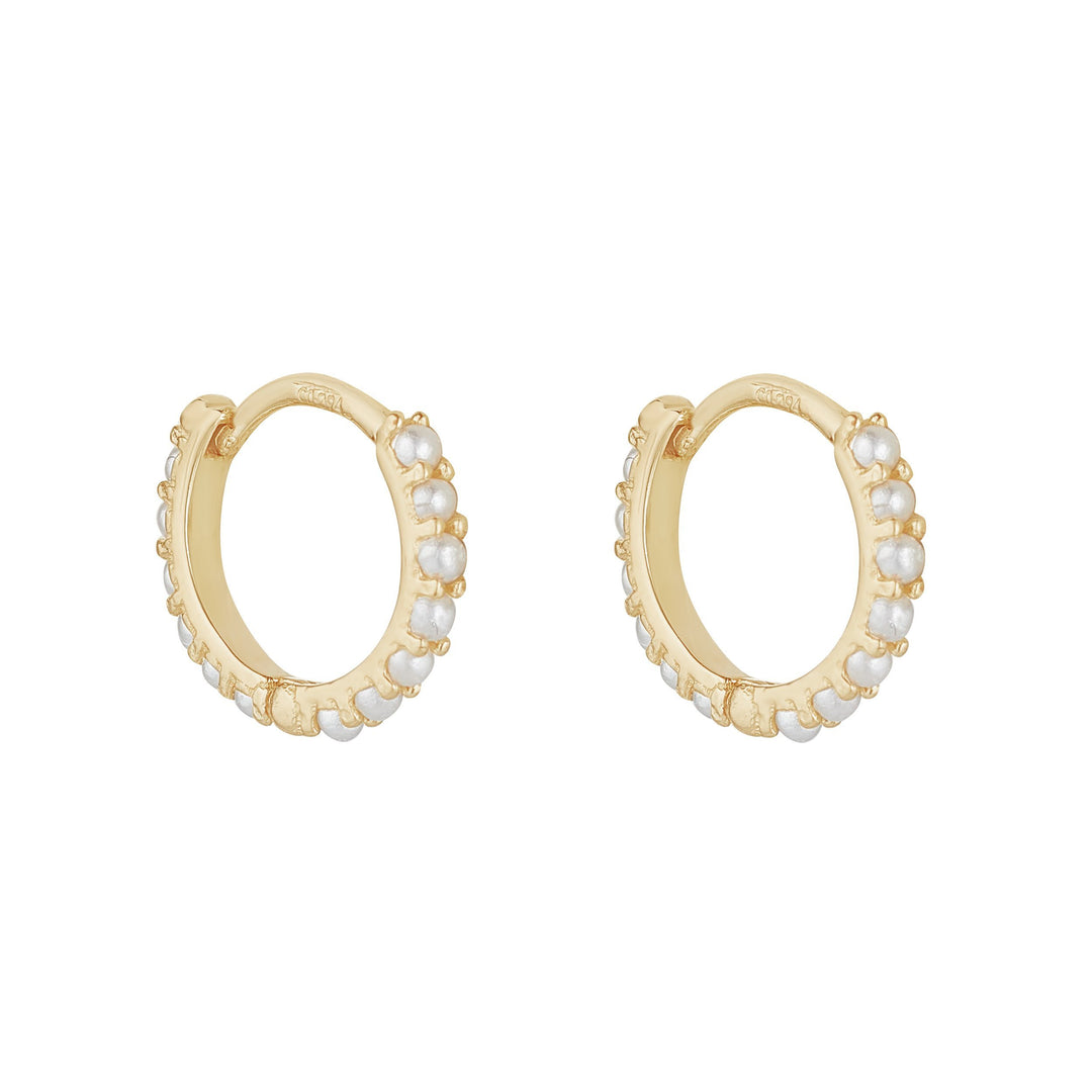9ct gold pearl huggie earrings on white background