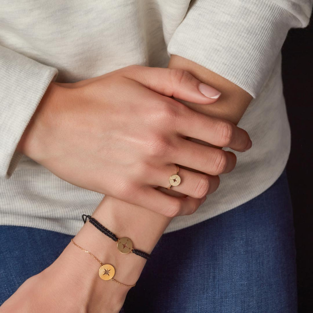 wrist of model displaying compass design gold chain bracelet