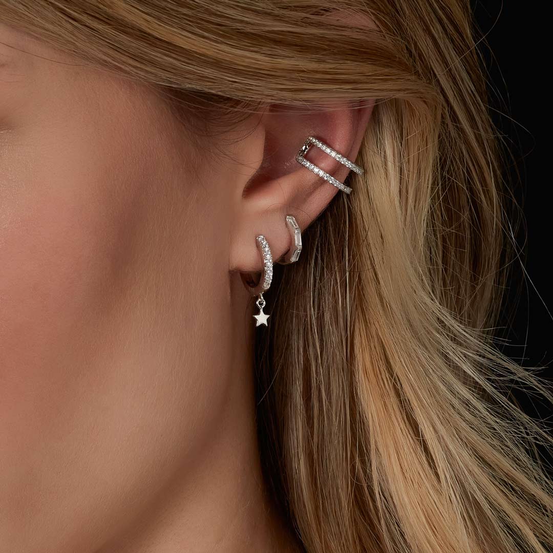 model wearing sterling silver star huggie earrings