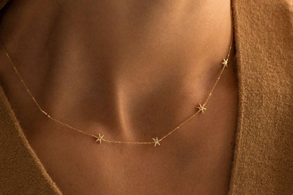 solid gold five star necklace on a model