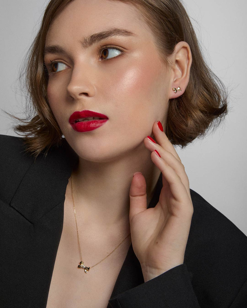 model wearing 9ct gold bow stud earrings and necklace set