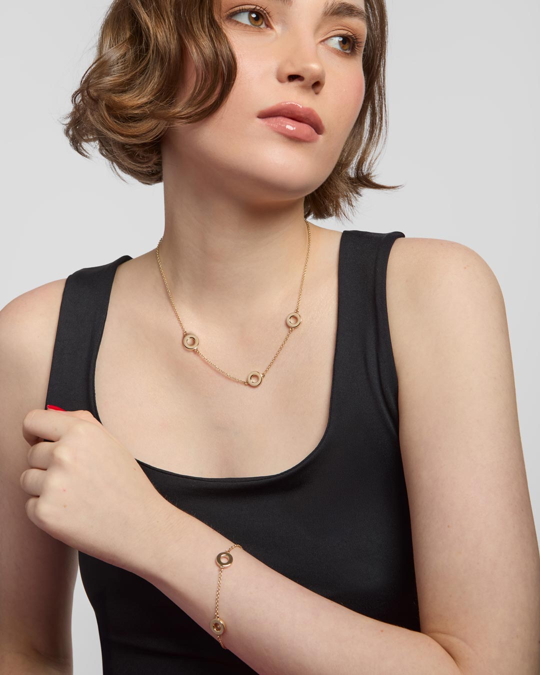 model wearing 9ct gold circle bracelet and necklace set
