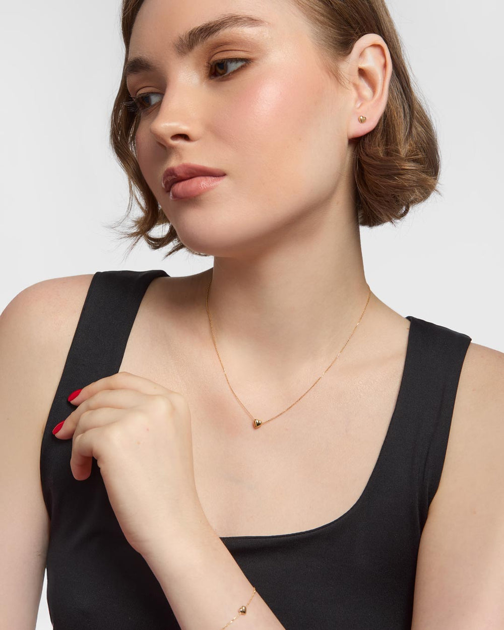 model wearing 9ct gold heart stud earrings, bracelet and necklace set
