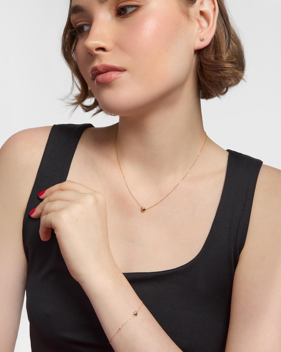 model wearing 9ct gold heart stud earrings, bracelet and necklace set