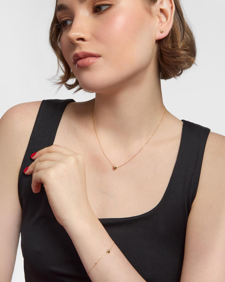 model wearing 9ct gold heart stud earrings, bracelet and necklace set