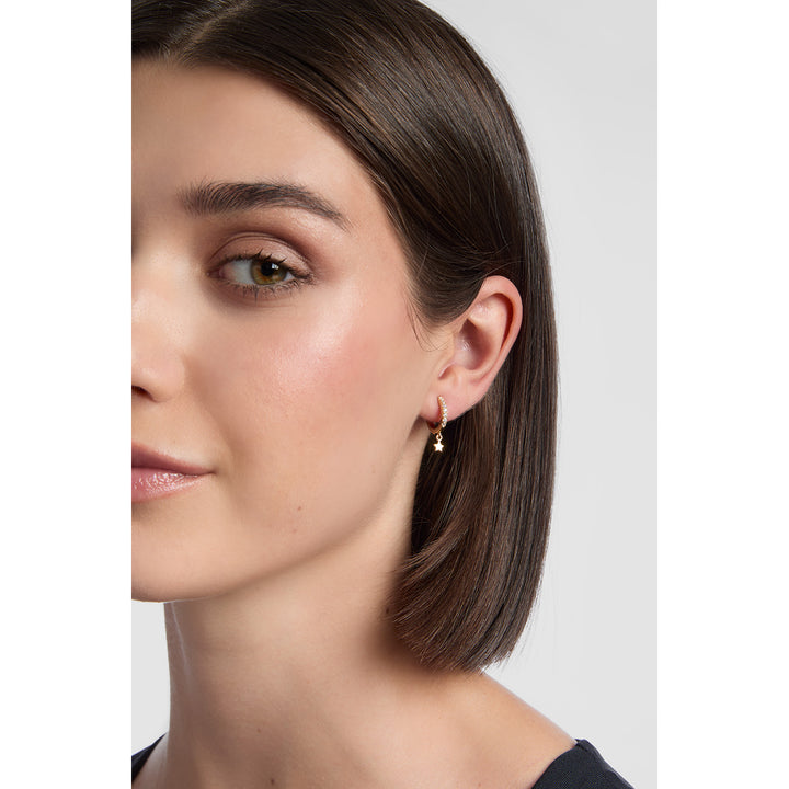 model wearing 18ct gold plated sterling silver Star Drop Cubic Huggie Earrings