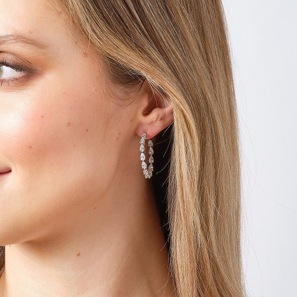 Silver pear shaped cz hoop earrings on model