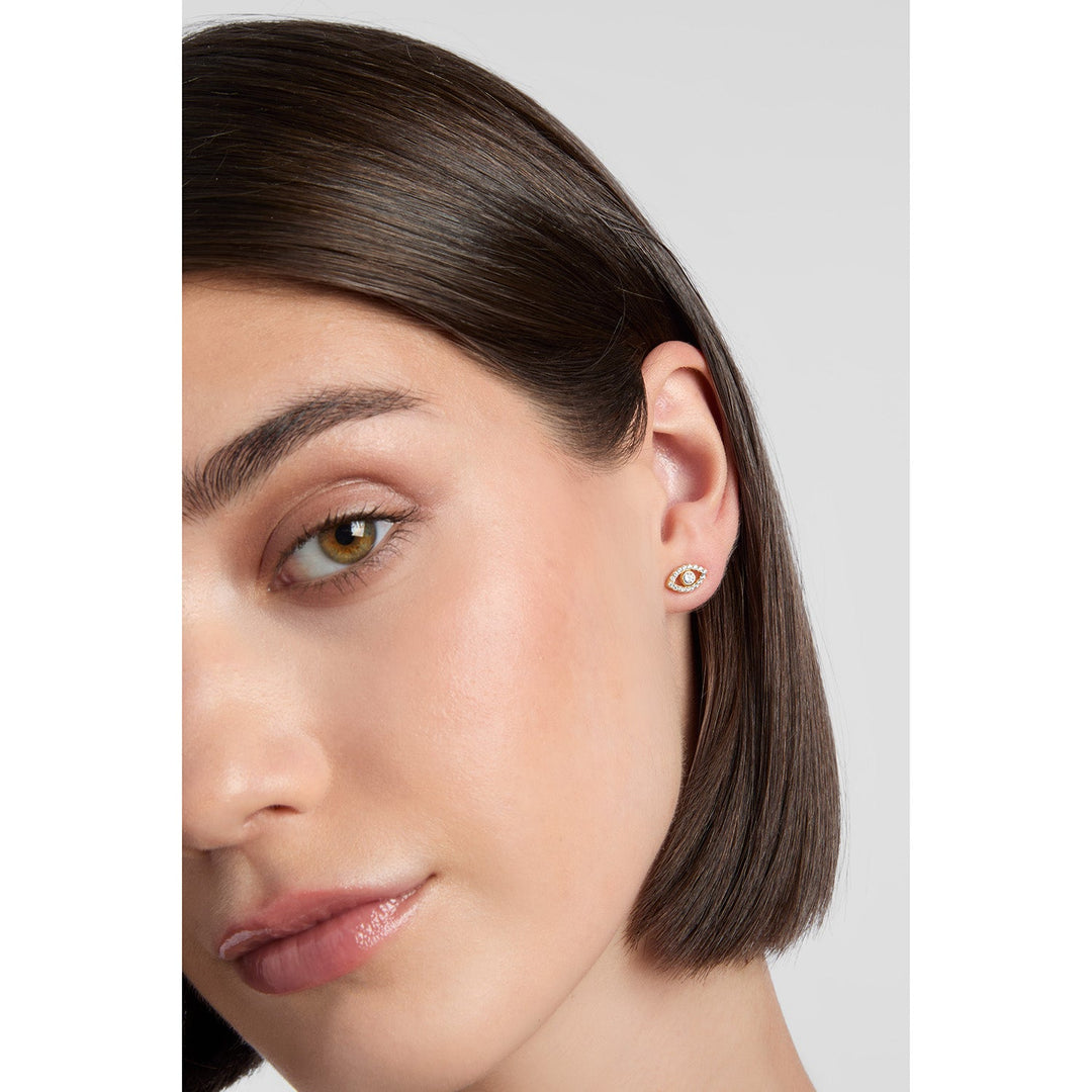 model wearing gold evil eye stud earrings