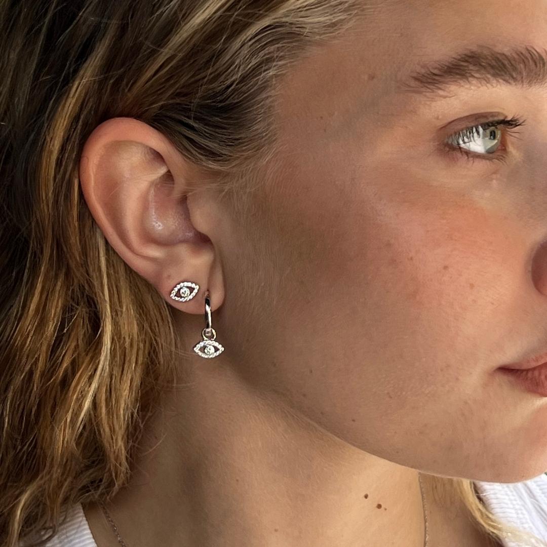 sterling silver evil eye stud earrings and huggie earrings on model