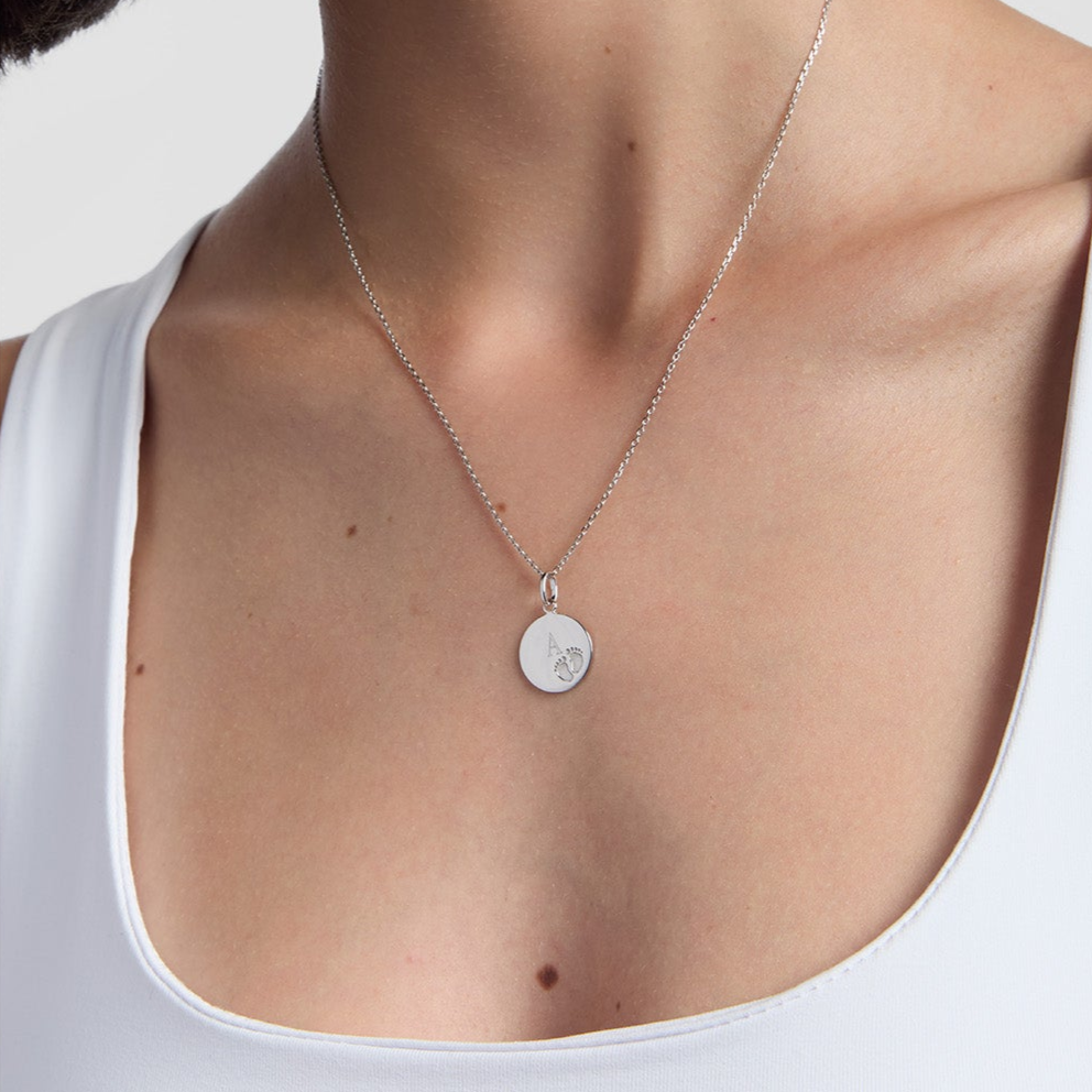 sterling silver engravable necklace with baby footprints on model