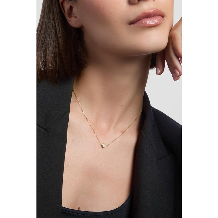 model wearing gold small clover necklace