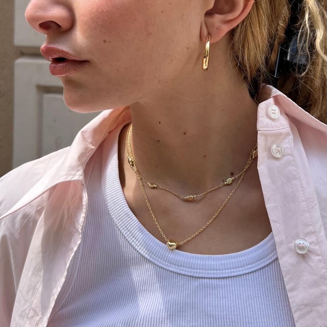 model wearing gold plated layered necklaces