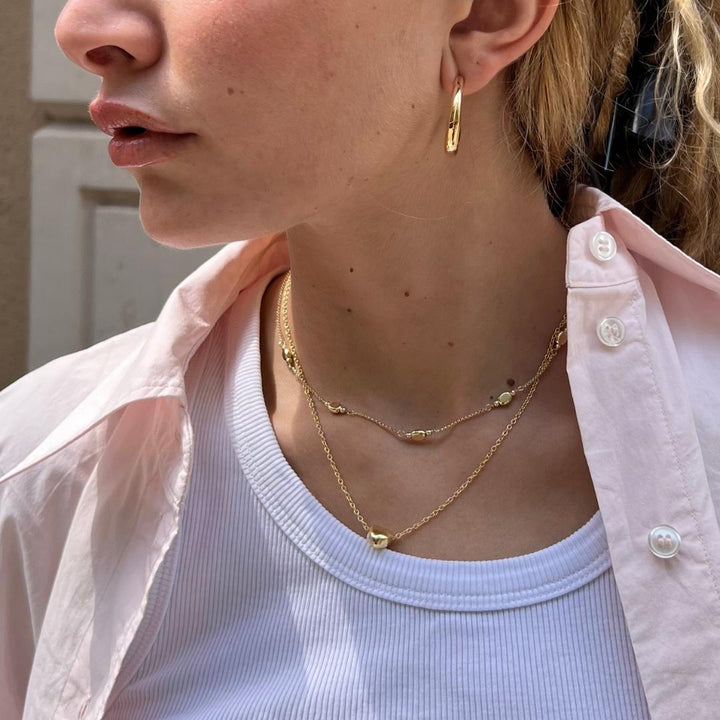 model wearing gold plated layered necklaces