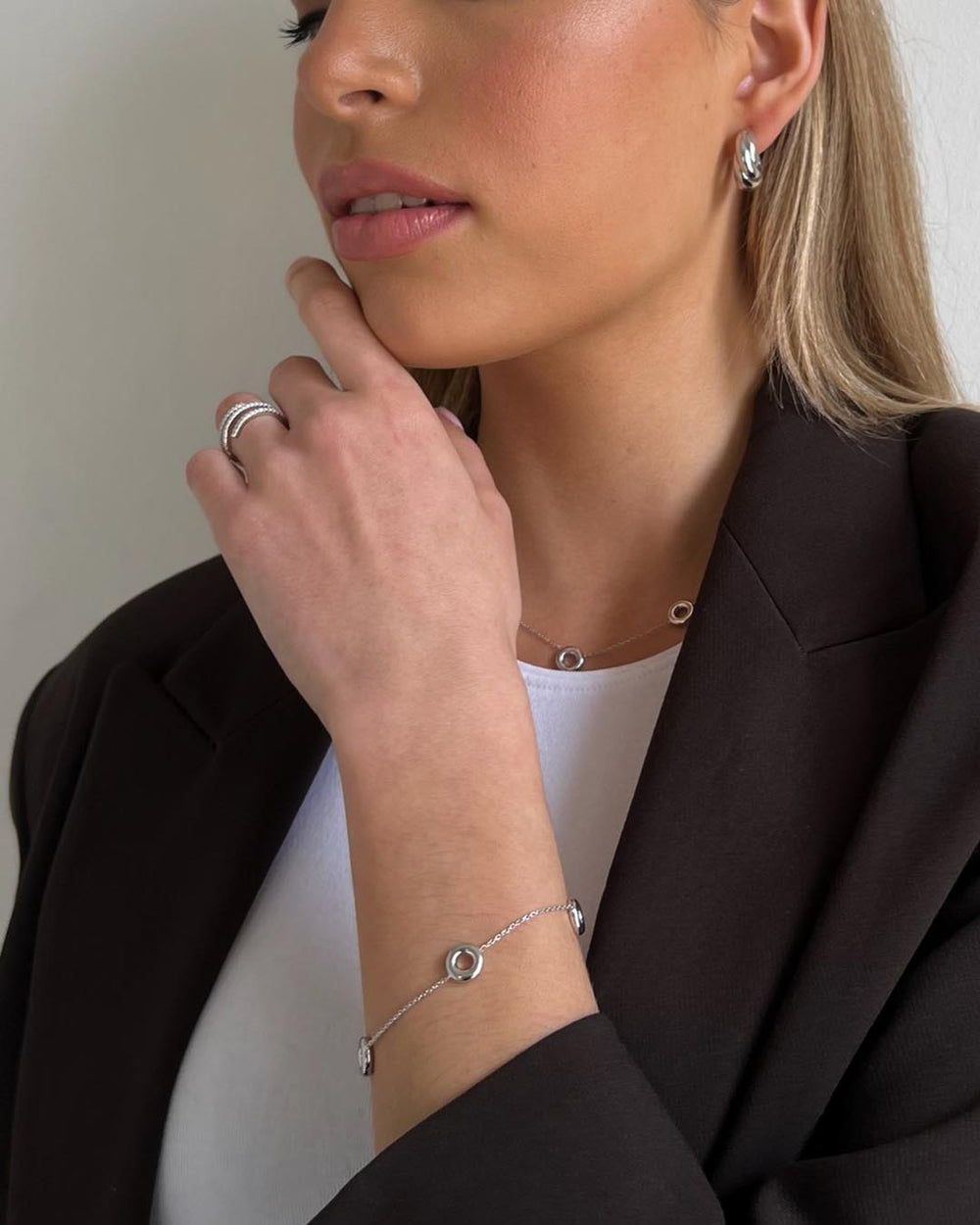 model wearing silver open circle necklace and bracelet and silver hoop earrings