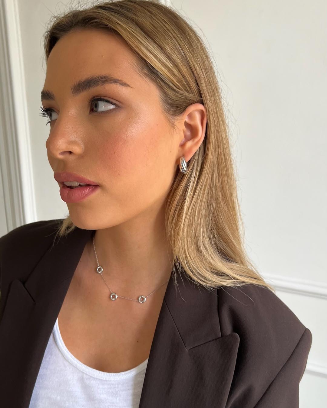model wearing silver open circle necklace and silver hoop earrings