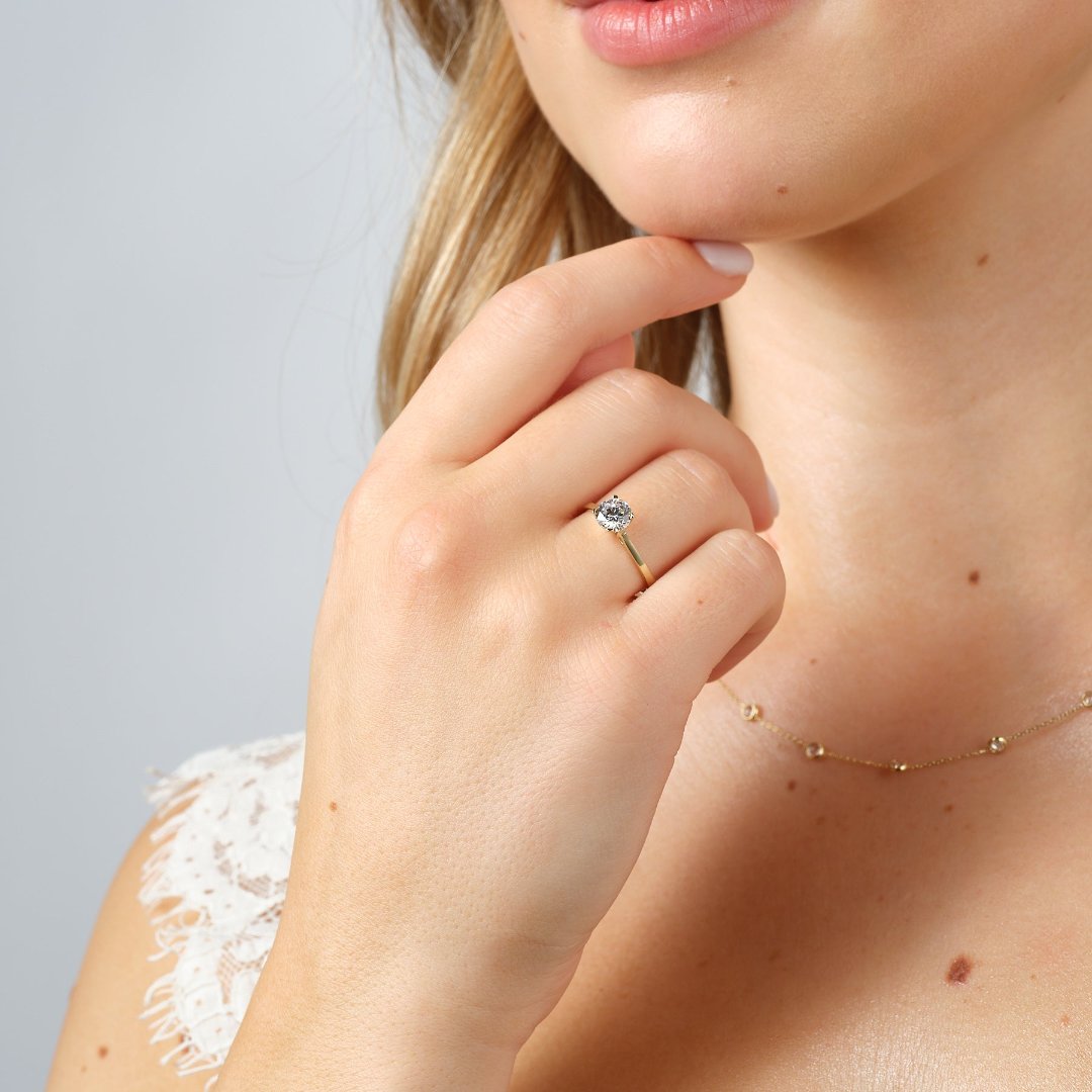 gold solitaire diamond ring on models hand