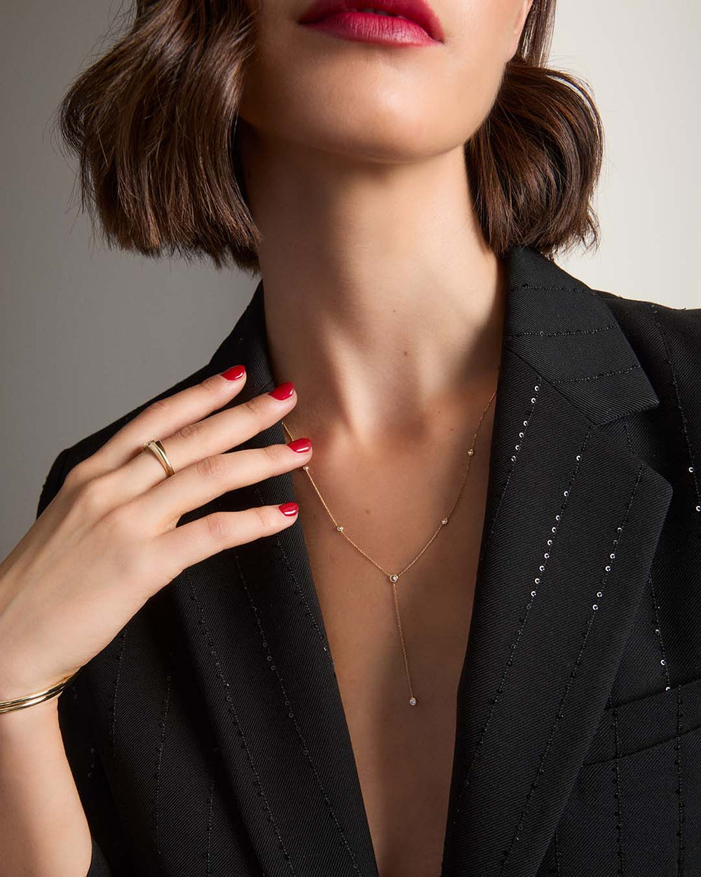 gold lariat necklace on model