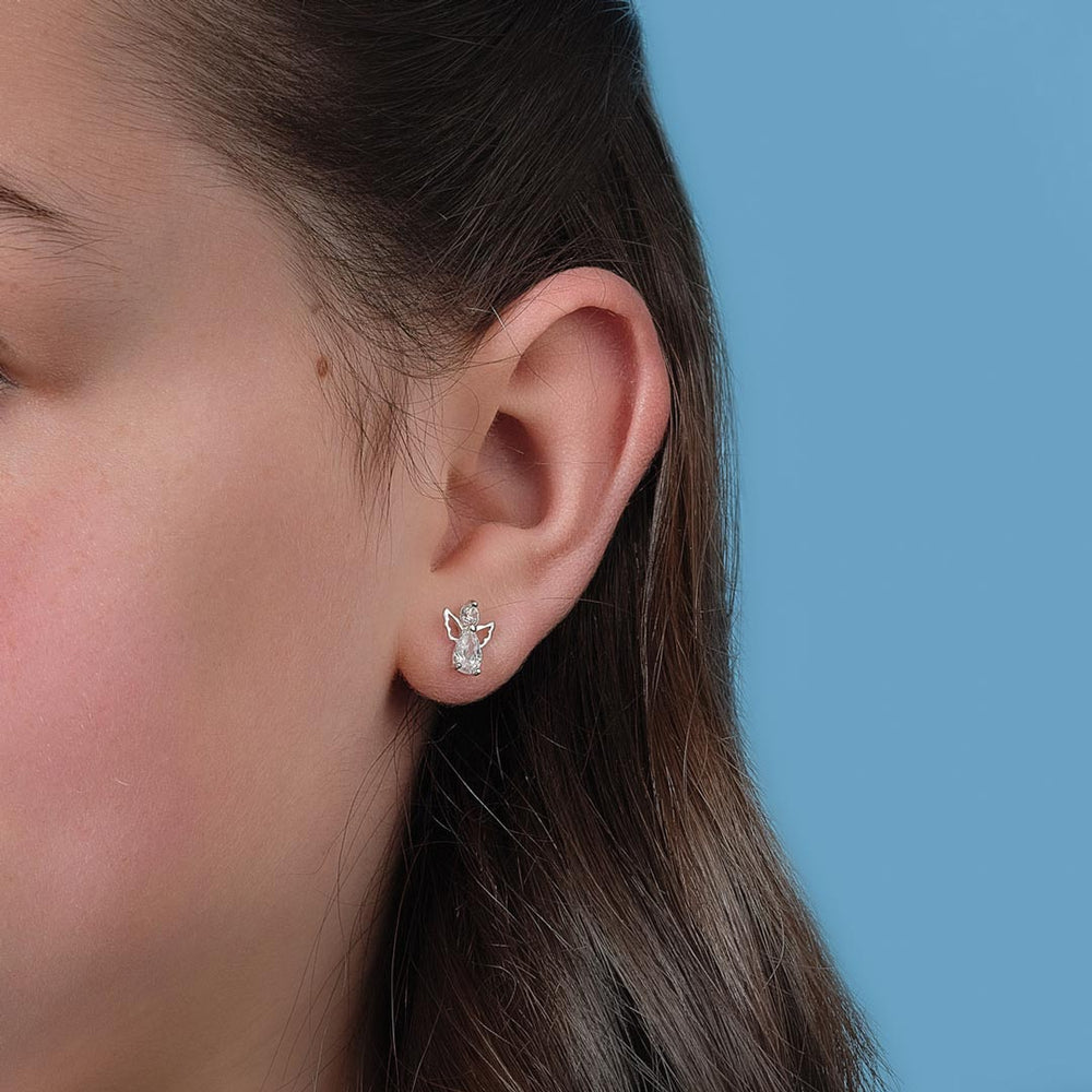 close-up image of silver angel stud earrings on a girl
