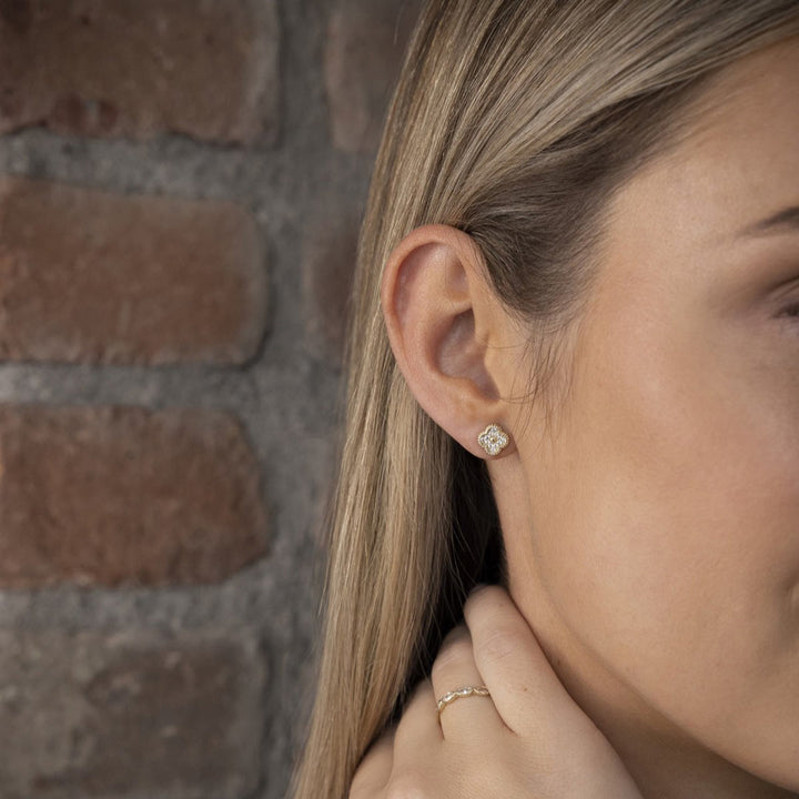 model wearing yellow gold flower stud earrings from NJO Designs