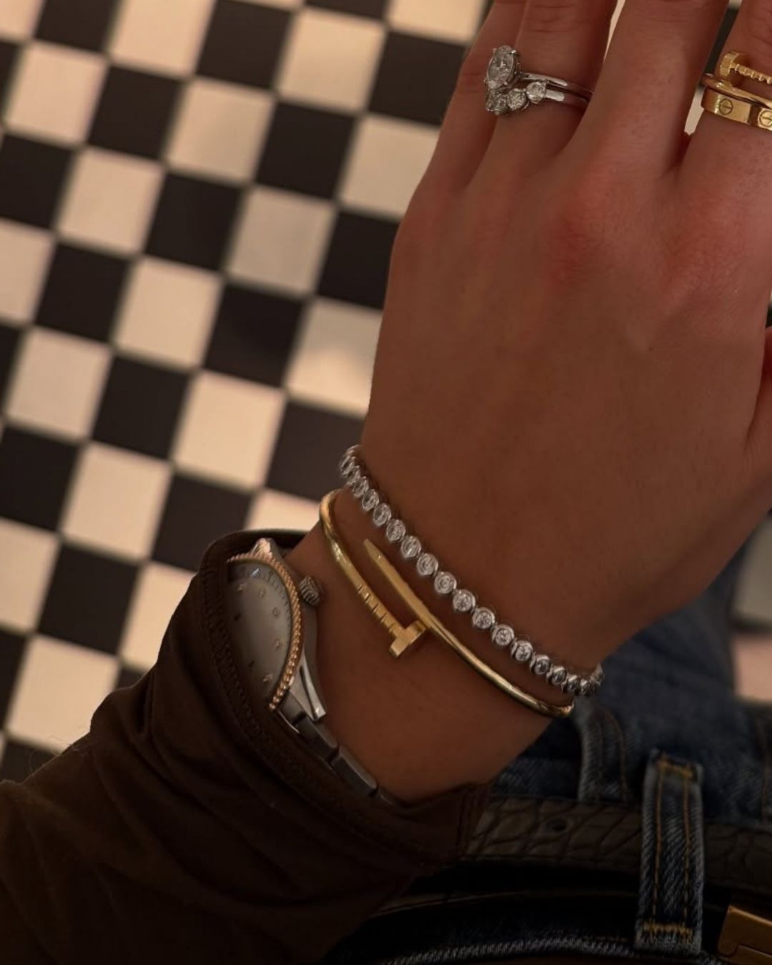 model wearing gold plated and sterling silver bangle stack with a silver watch and ring stacks