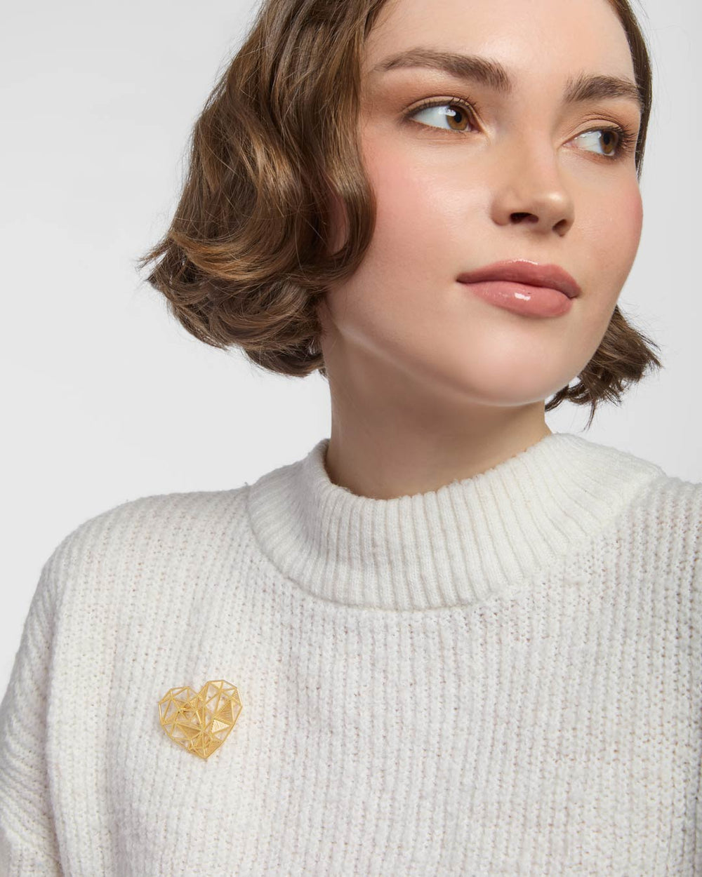 model wearing gold plated heart brooch