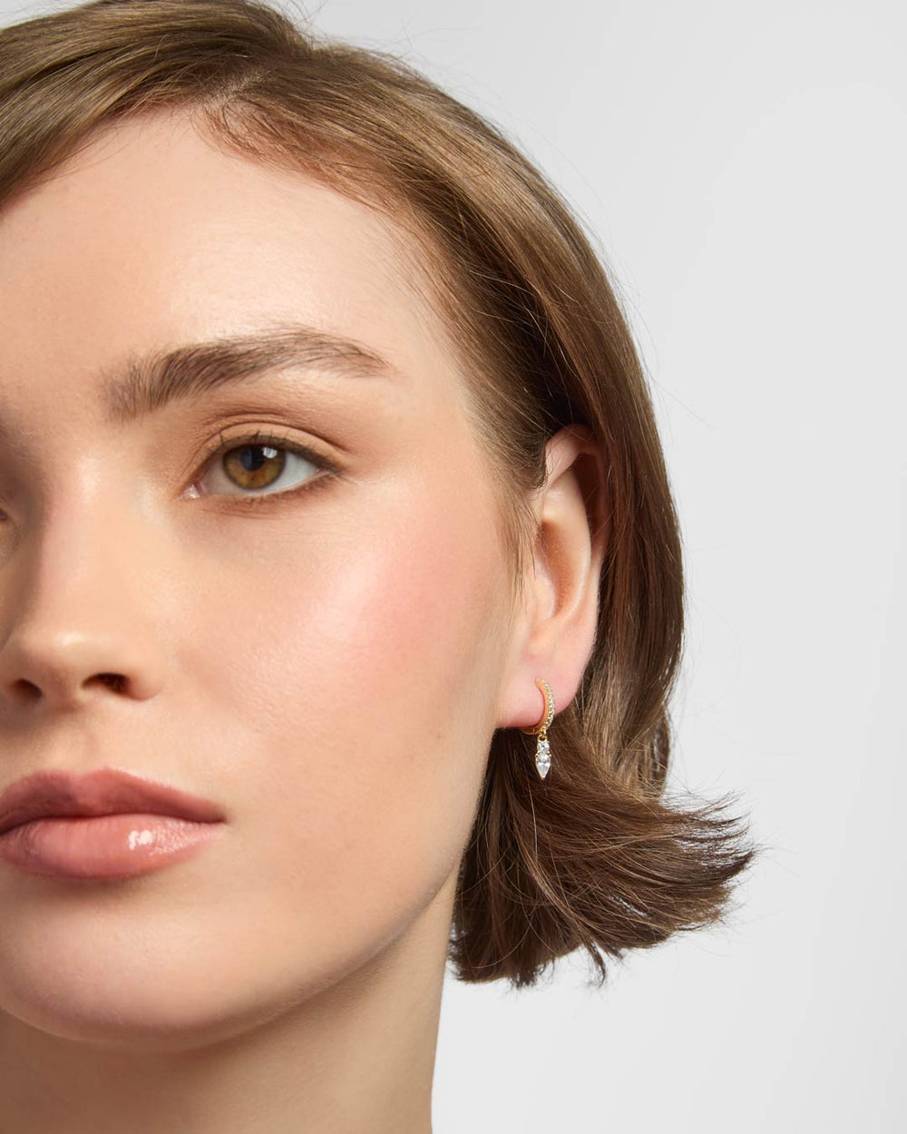 gold plated huggie earrings on model