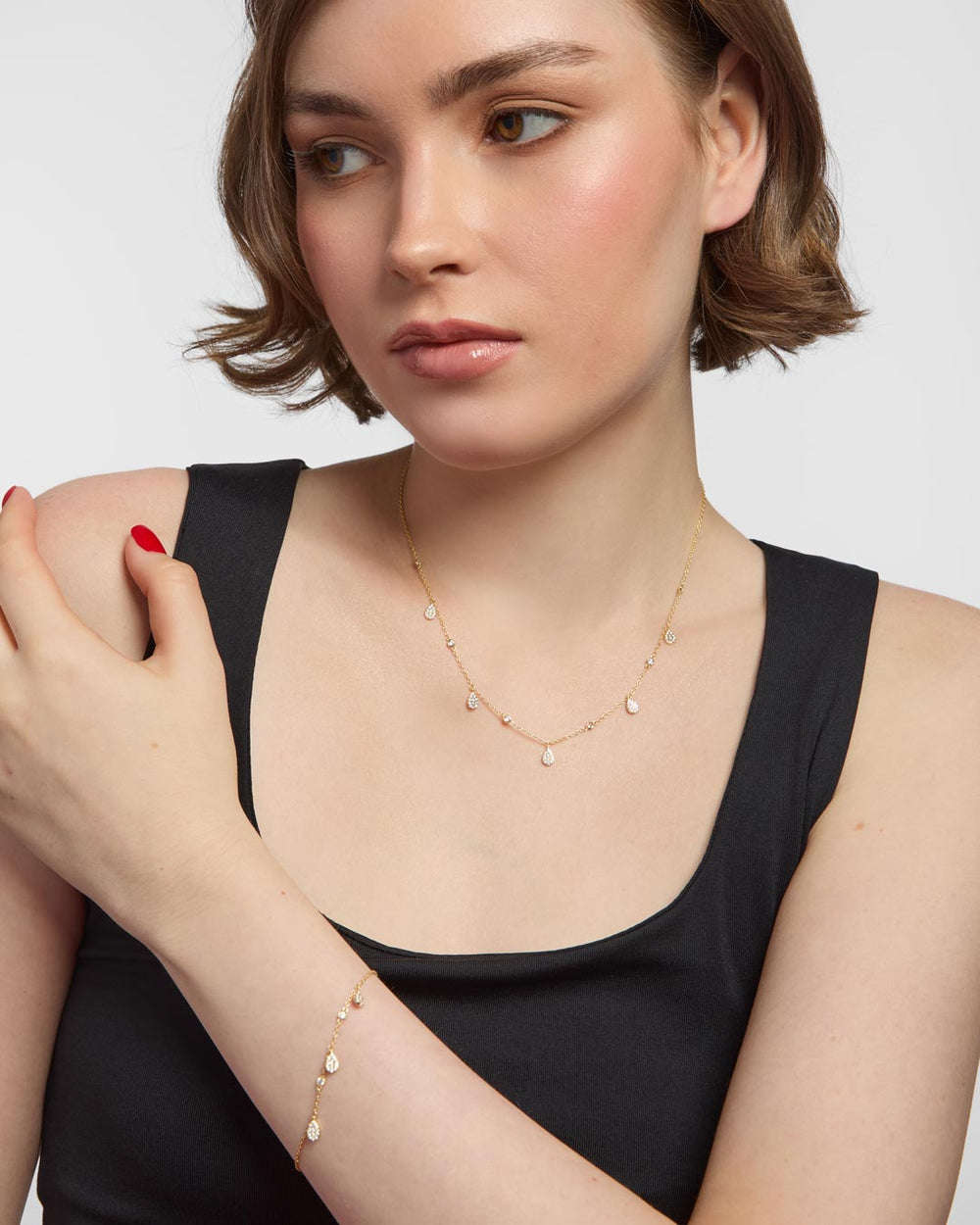 model wearing gold plated charm necklace and bracelet