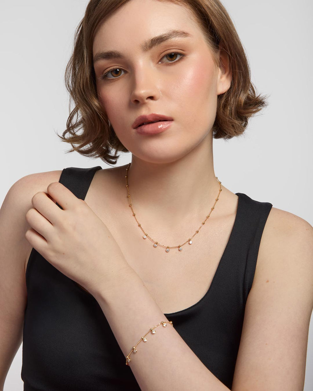 model wearing gold plated charm necklace and bracelet