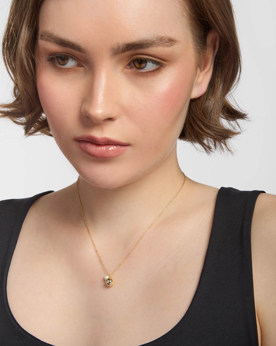 model wearing gold plated pearl charm necklace