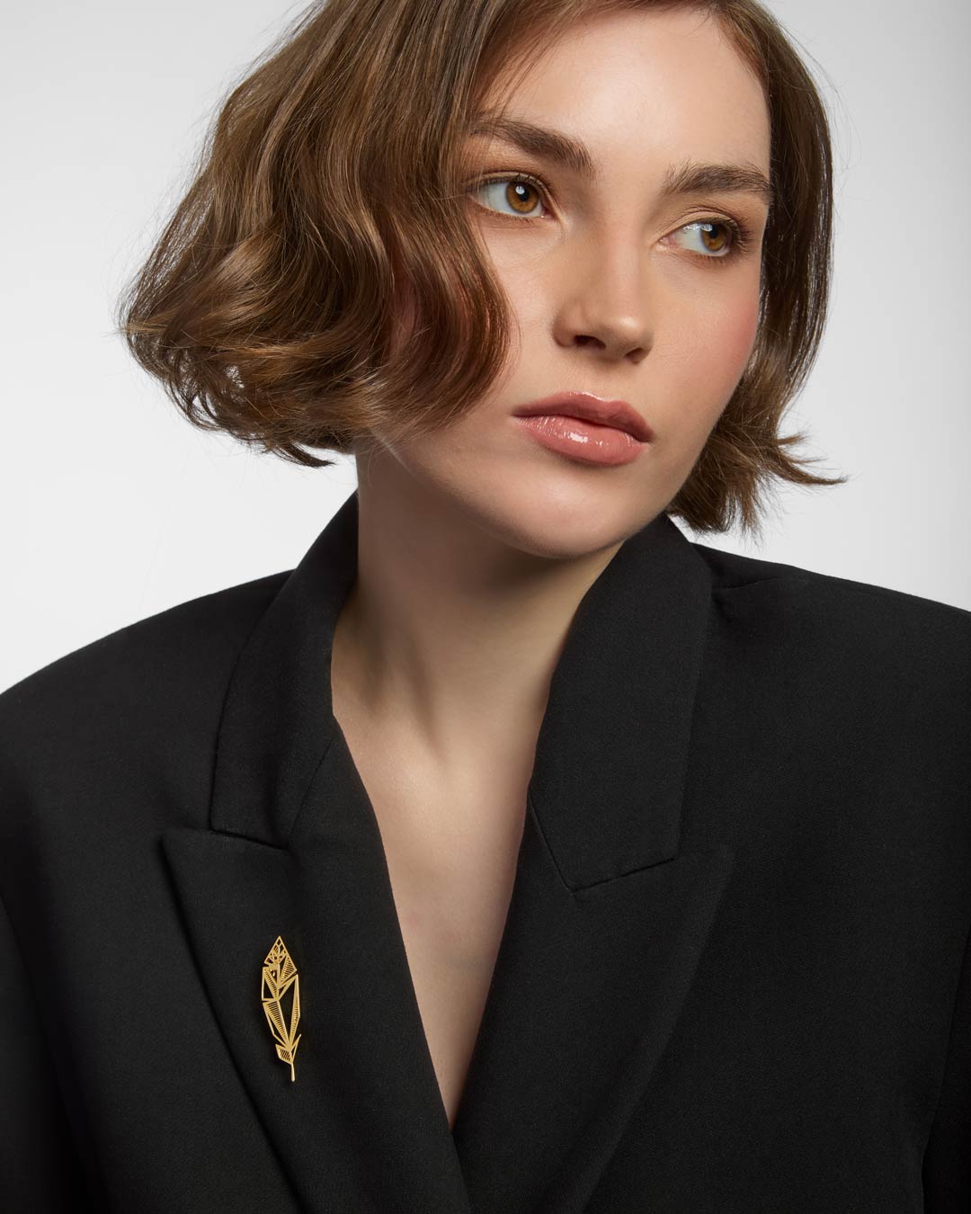model wearing gold plated rose brooch