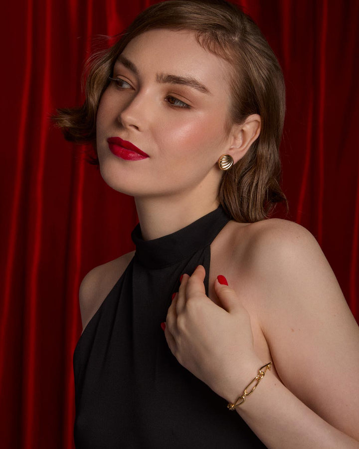 model wearing gold plated stud earrings and link bracelet
