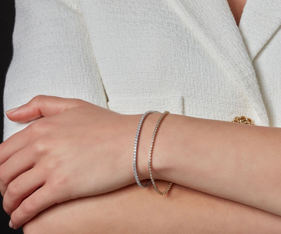 model wearing 9ct gold and sterling silver tennis bracelets stacked