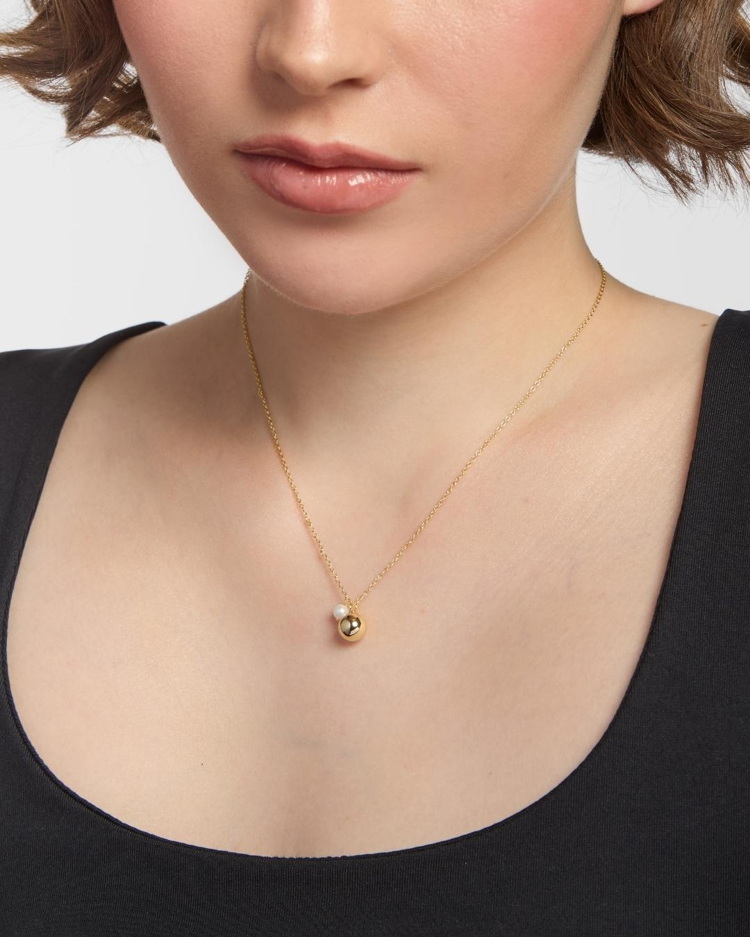 model wearing gold plated necklace with a pearl charm