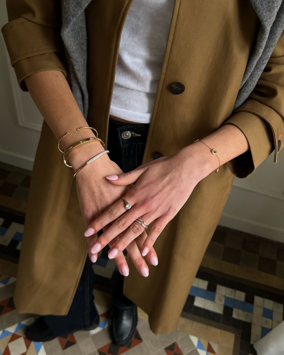 Layered silver and gold bracelets by NJO Designs styled elegantly on a woman’s wrist