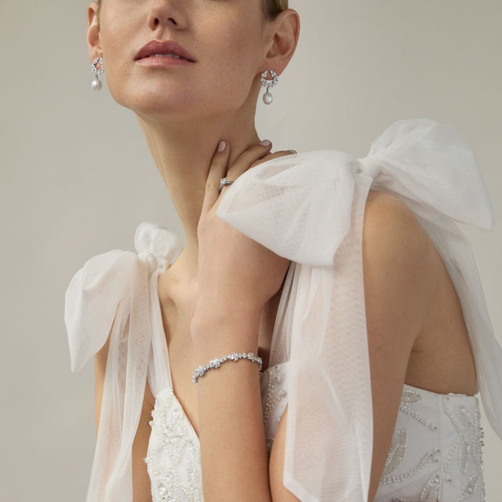 model wearing sterling silver cz pearl drop earrings and cz bracelet