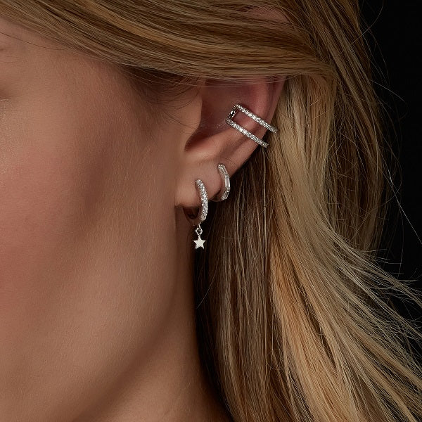 model wearing sterling silver star huggie earrings