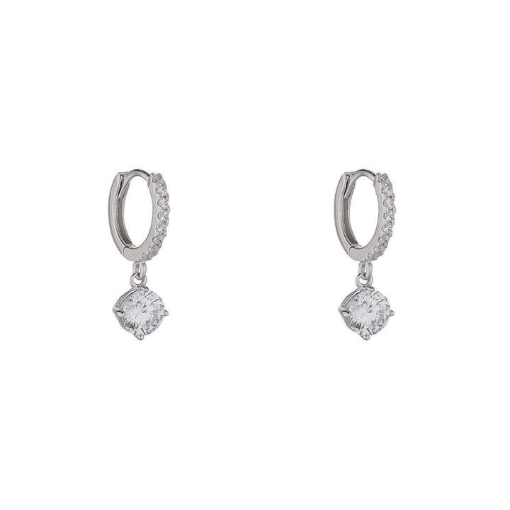silver huggie earrings with cubic drop on white background