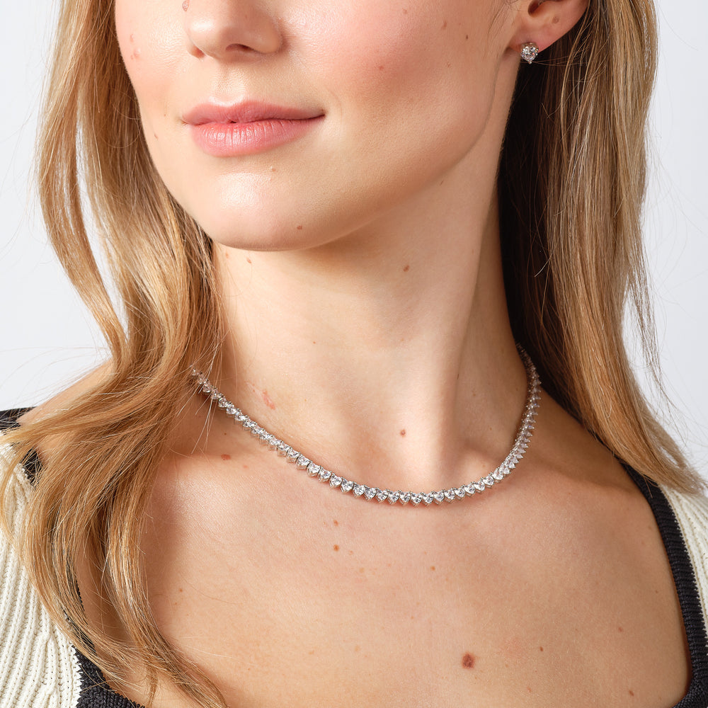 Model wearing silver heart stud earrings