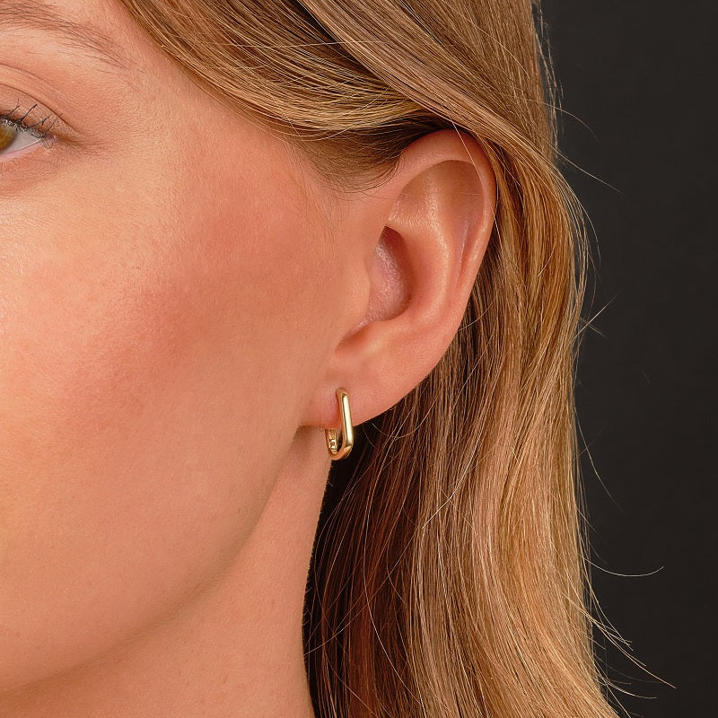 model wearing gold huggie earrings