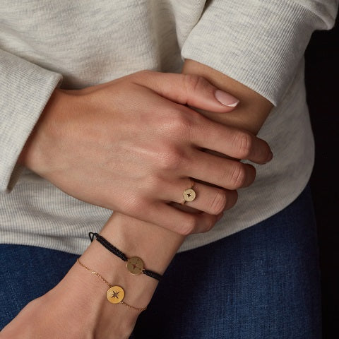 wrist of model displaying compass design gold chain bracelet 