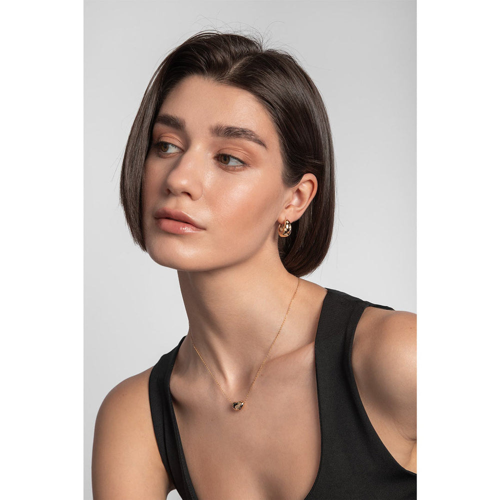 yellow gold bean-shaped necklace and earrings set on a model
