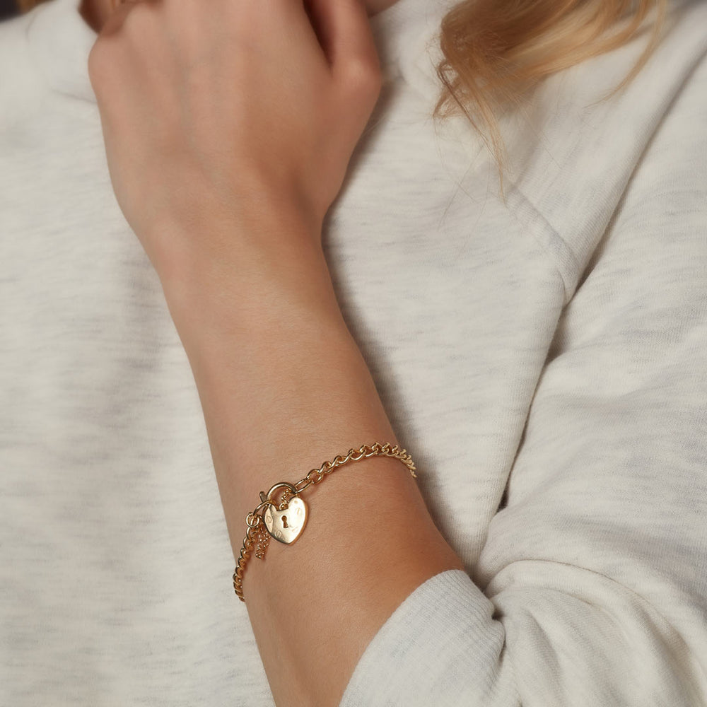 model wearing gold bracelet with padlock attached