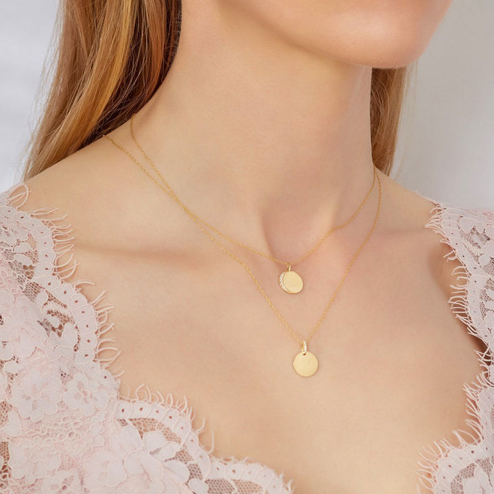 yellow gold engravable disc necklaces on a model