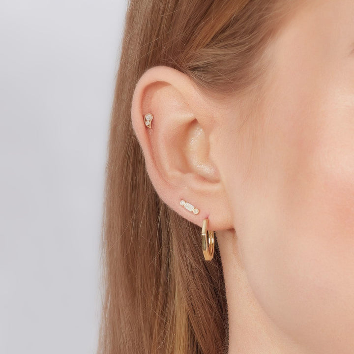 gold earring stacks on a model
